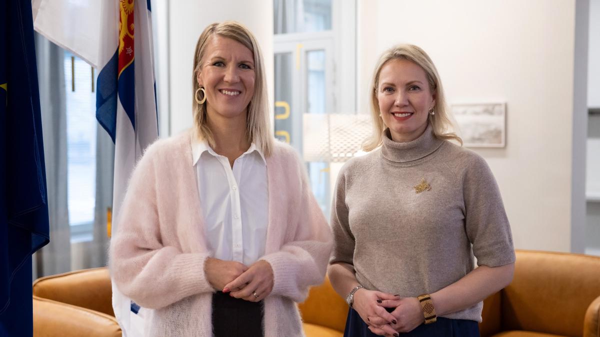 Minister Multala och generalsekreterare Tanhuanpää står bredvid varandra och ler.