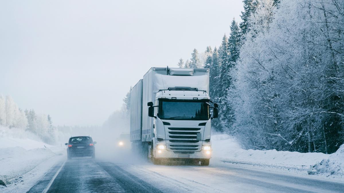Lumisessa maisemassa ajava valkoinen rekka