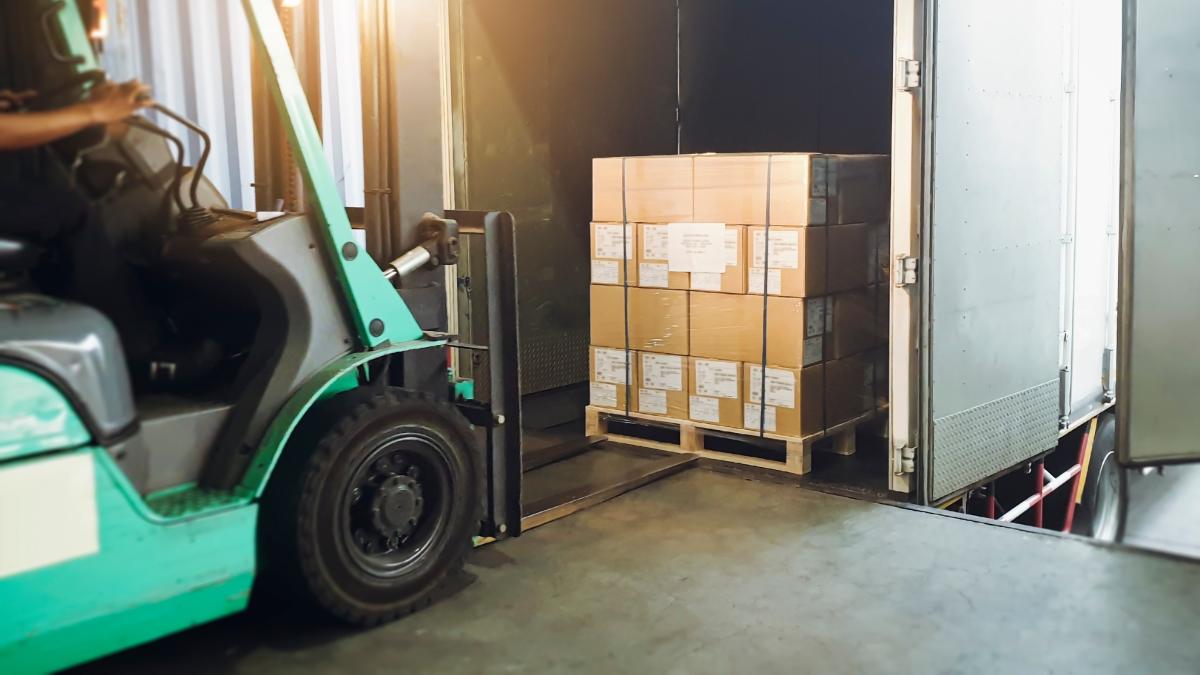 Gaffeltruck och pall med kartonger