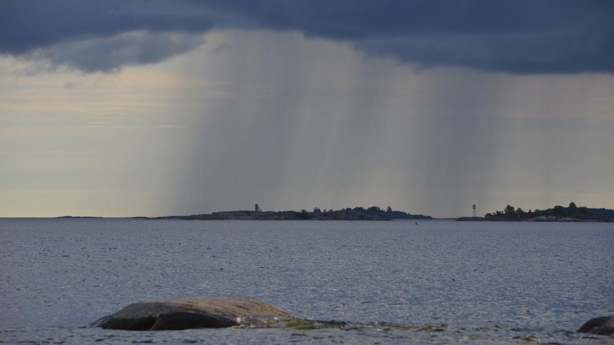 Matalia saaria Itämeren horisontissa. Saarille lankeaa sateita.